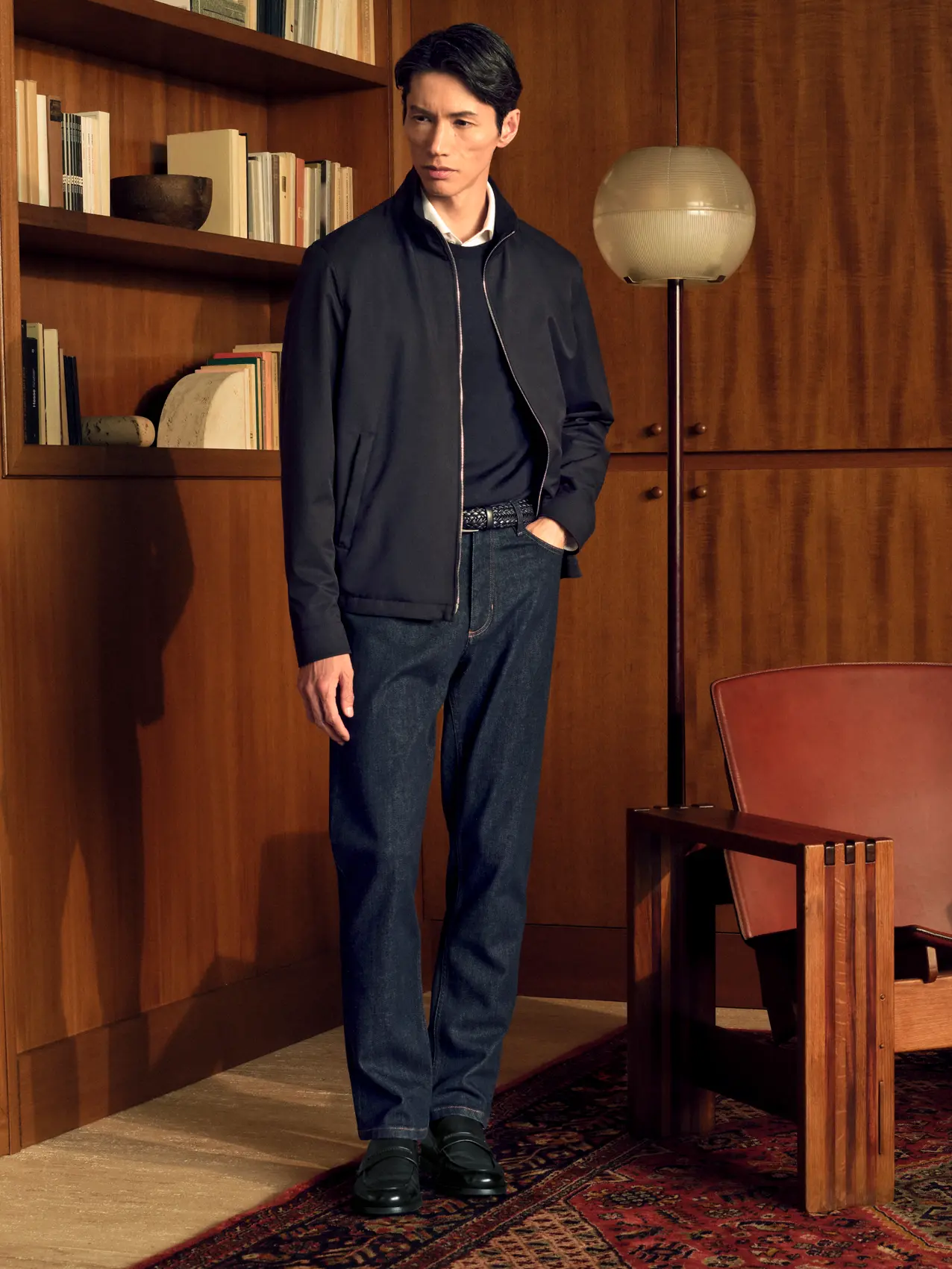 Man in a refined casual look wearing a Motorin zip blouson with dark denim jeans, from the ZEGNA Fall/Winter 2026 collection.