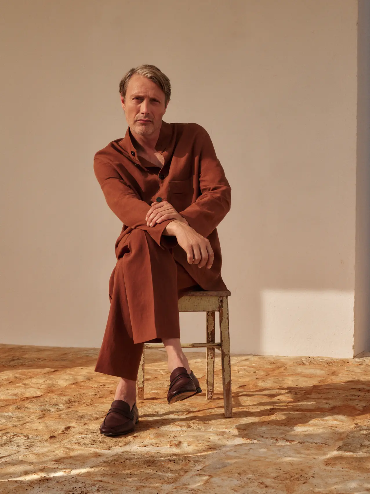 Mads Mikkelsen 身穿精緻的素色麻布服裝，配搭 ZEGNA SS25 系列的皮革便鞋。