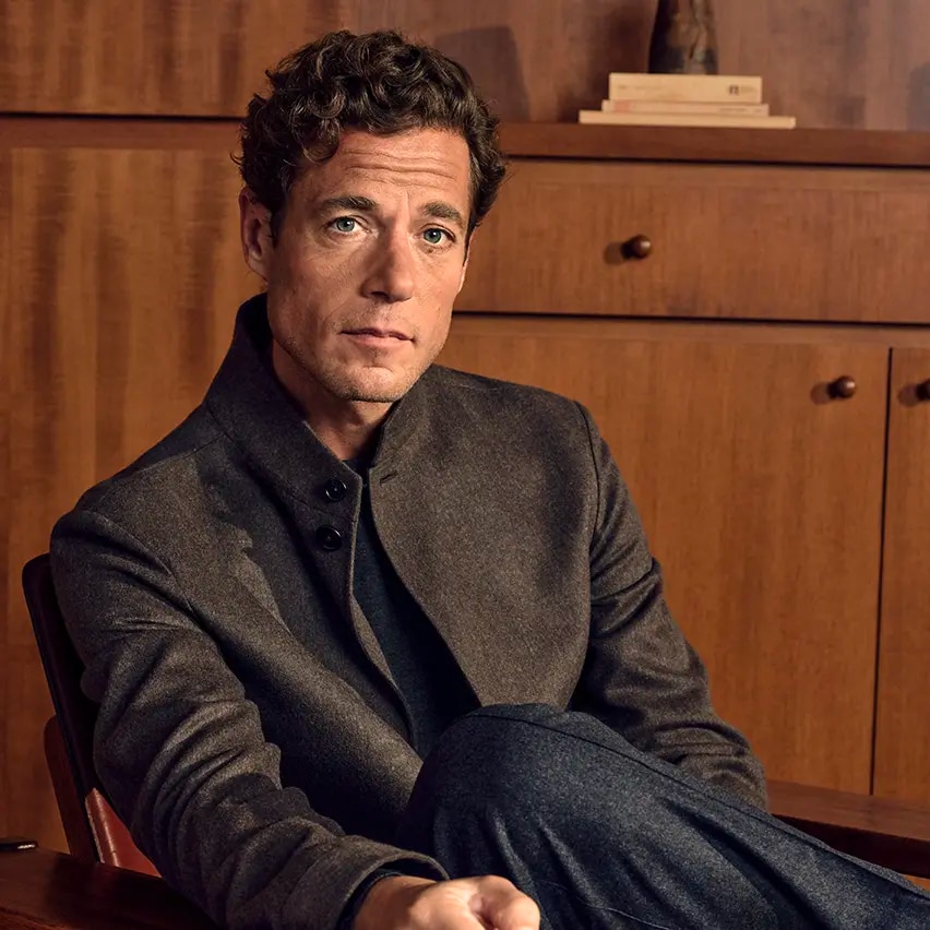 Man seated wearing the Oasi Cashmere Beaver Il Conte Chore Jacket in dark olive green multimelange with a Cashseta crew neck and wool, silk and cashmere pants in dark grey, from the ZEGNA Fall/Winter 2026 collection.