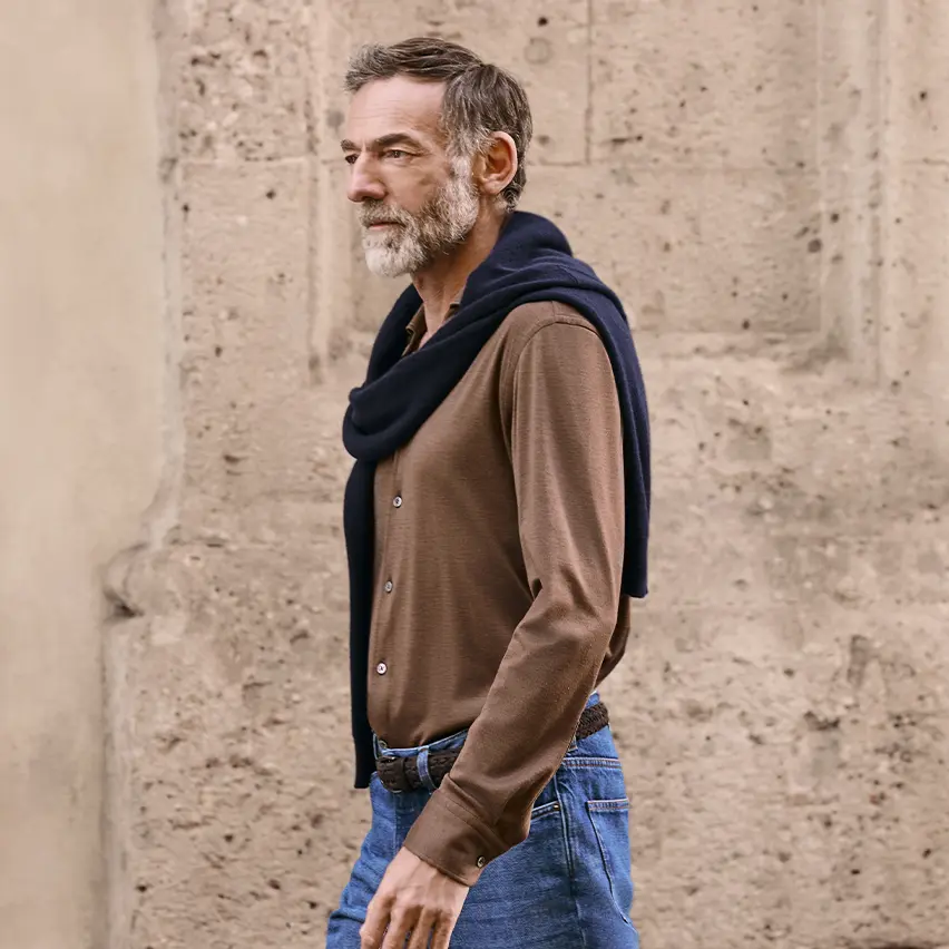 一位造型精致休闲的男士身着 ZEGNA(杰尼亚)FW25 系列羊绒毛衣与牛仔裤。