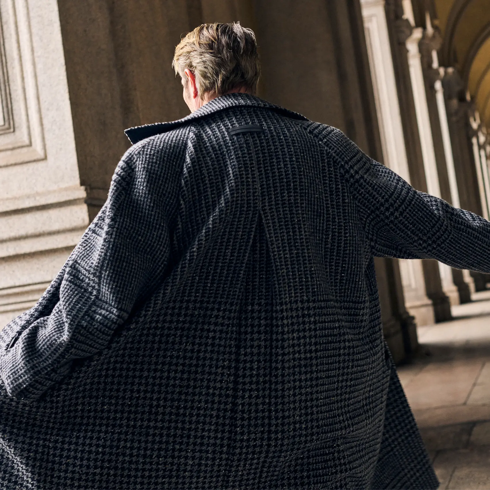 Mads Mikkelsen wearing a coordinated houndstooth coat and suit in Torino style, from the ZEGNA FW25 collection.