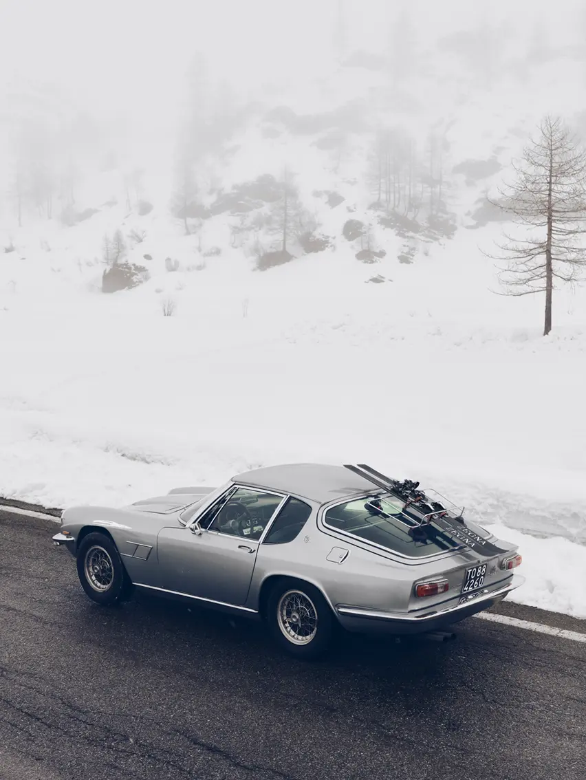 Sports car in a snowy landscape featuring ZEGNA skis, Fall Winter 2025 collection campaign.