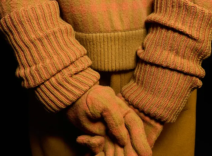 A man in an orange ZEGNA cashmere outfit with matching gloves.