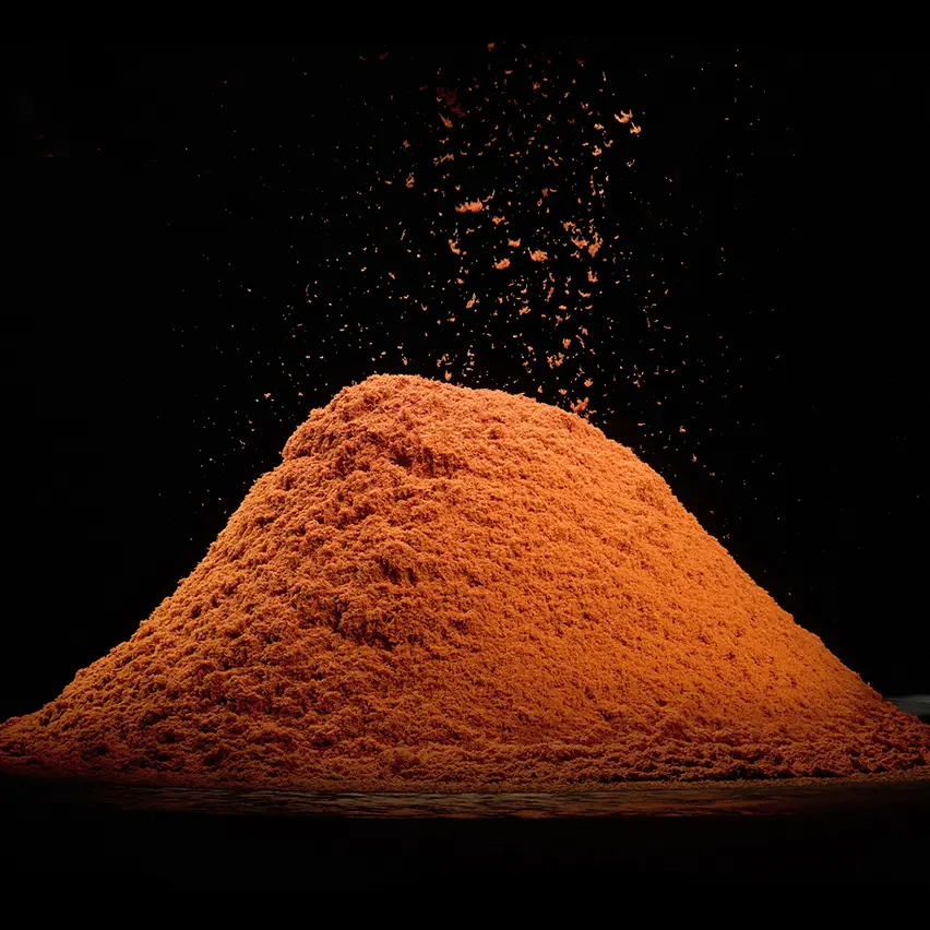 在黑色的背景下，一堆亮麗的橙色山羊絨纖維整齊地排列。