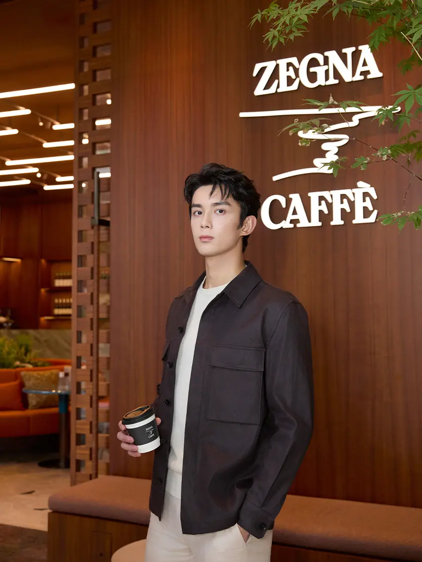 Wu Lei at the ZEGNA Shanghai Taikoo Café, wearing a black overshirt and Triple Stitch sneakers.