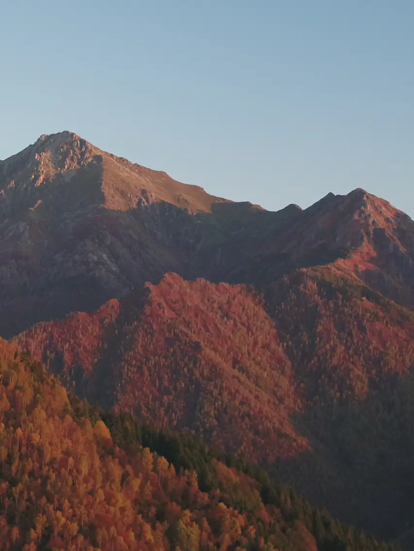 山巒層疊，暖光輕灑，天地無垠，靜謐深邃。