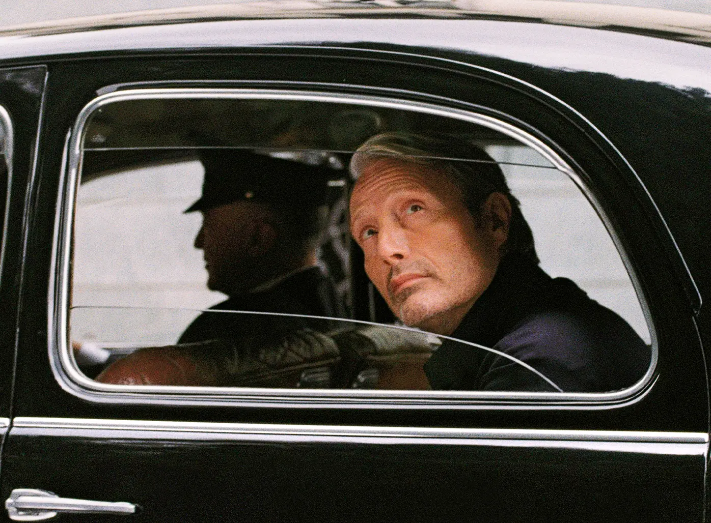 Mads Mikkelsen 的精緻 ZEGNA 造型特寫，他安坐於黑色汽車中。