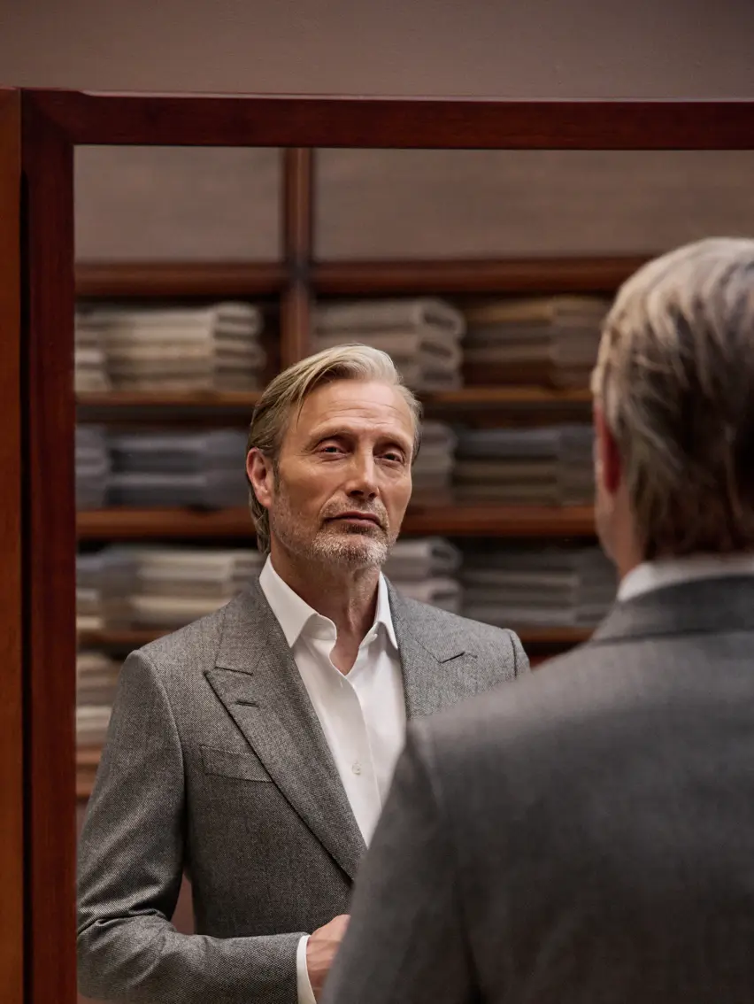 Mads Mikkelsen wearing a refined grey ZEGNA suit during an appointment with his tailor.
