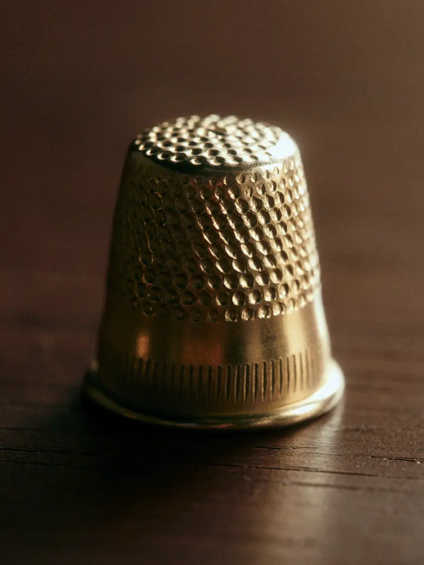 Close up of a thimble on a wooden table.
