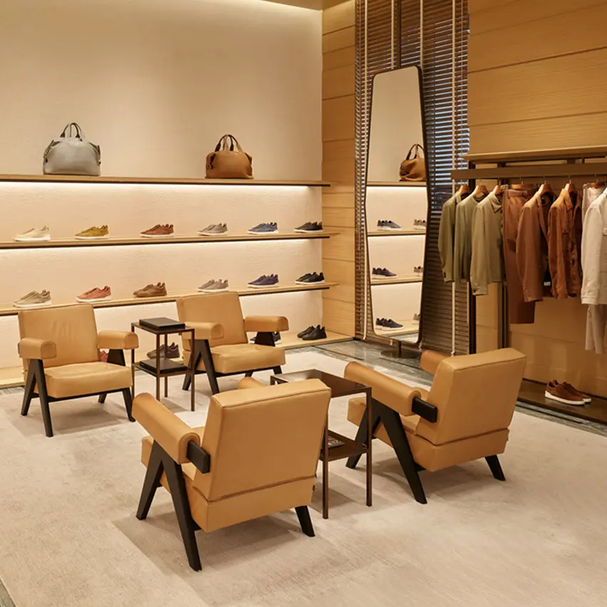 Interior of ZEGNA luxury boutique with shoes, bags, and clothing elegantly displayed on shelves.