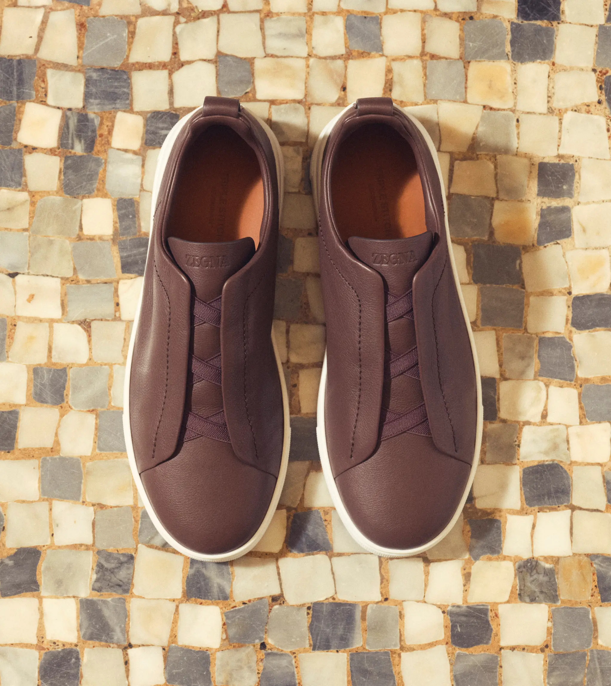 来自 ZEGNA（杰尼亚）2025 秋冬系列的深棕色皮革 Second Skin Triple Stitch 运动鞋正面图。