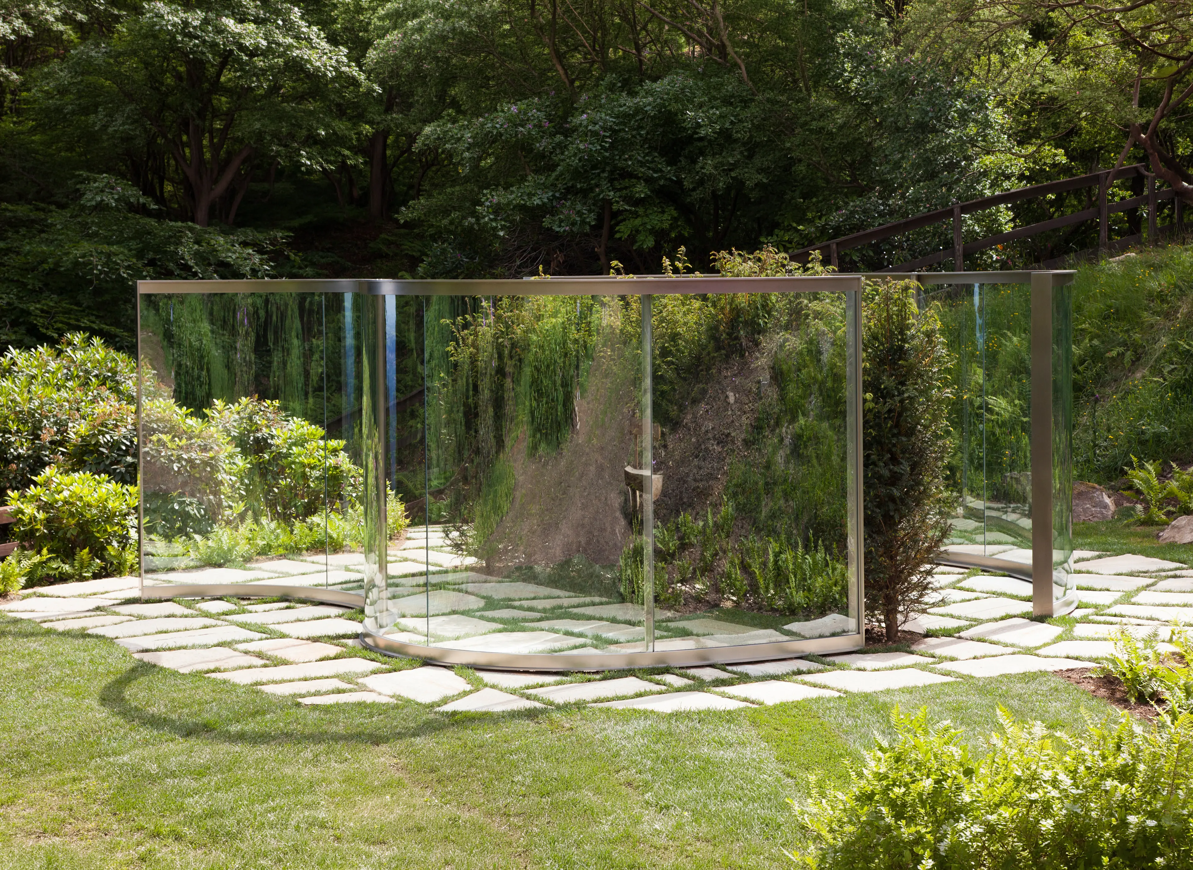 Mirrored outdoor installation surrounded by greenery at ZEGNA HQ.