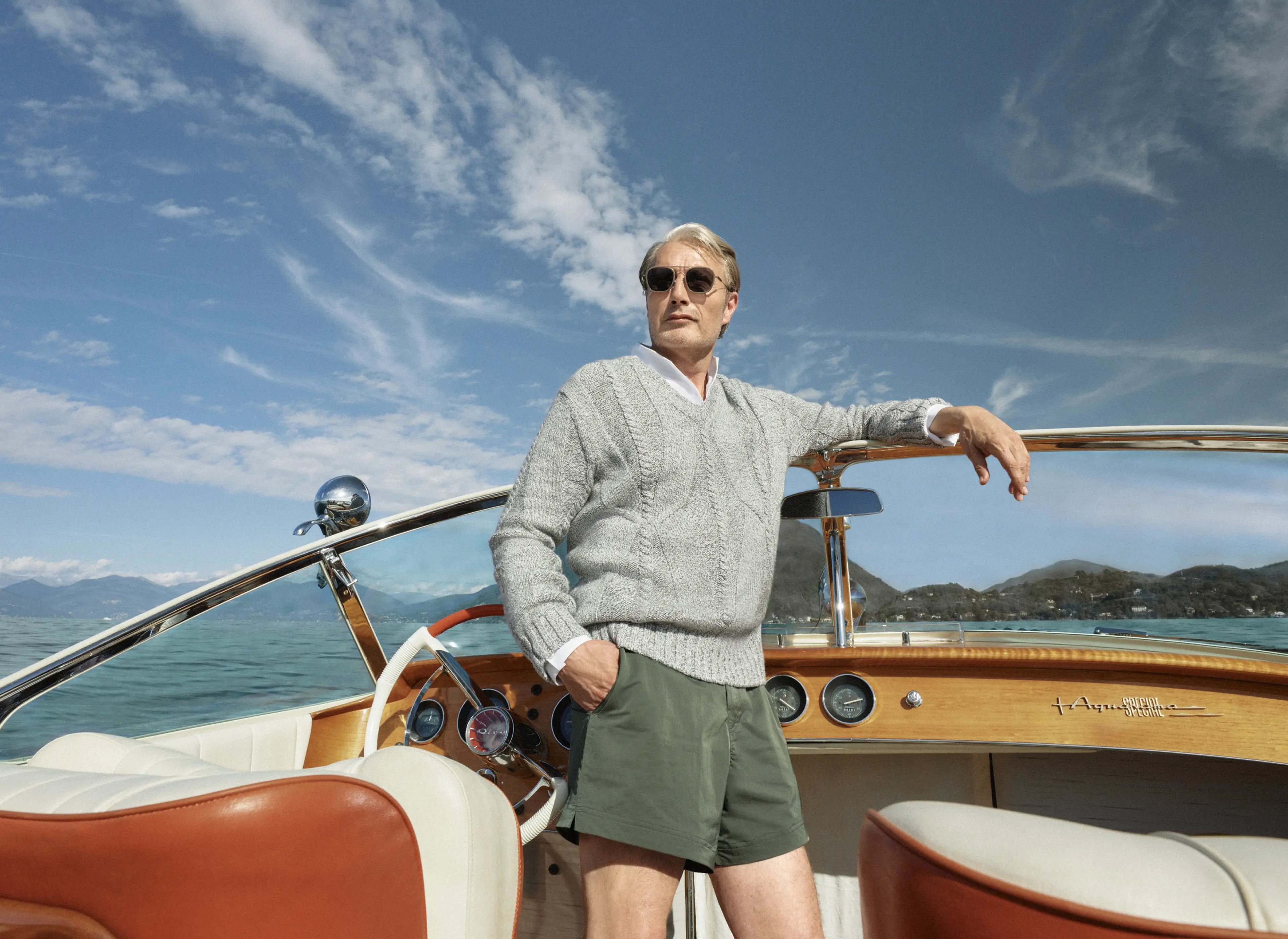 Mads Mikkelsen on a boat wearing a ZEGNA Spring Summer 2026 look featuring a V-neck sweater and the iconic Rio beachwear