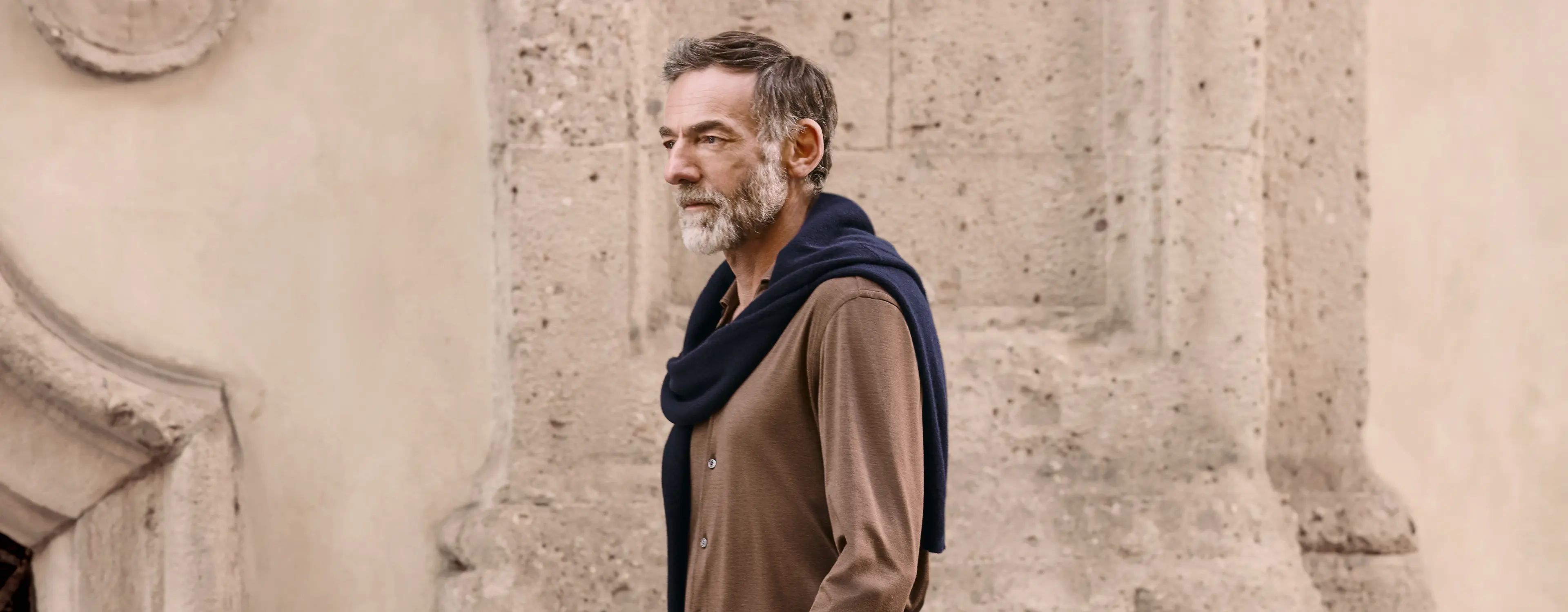 Man in a refined off-duty look with cashmere sweater and jeans, from the ZEGNA FW25 collection.