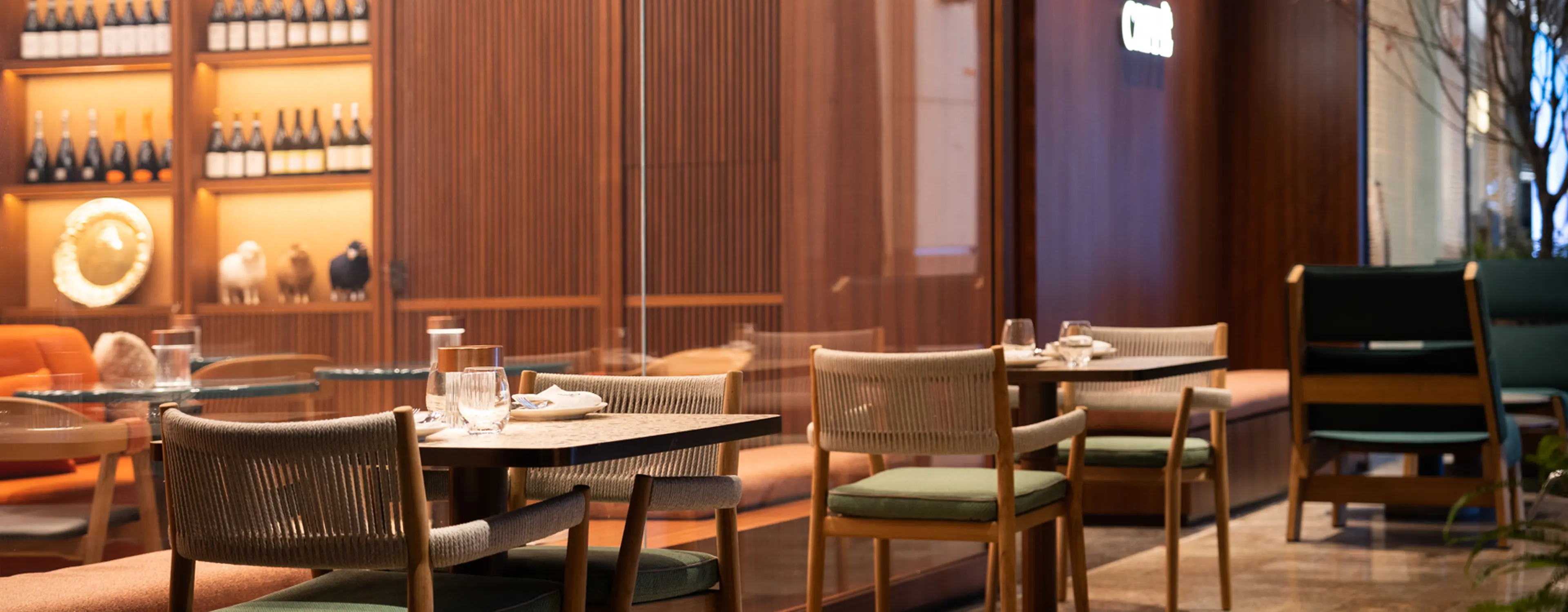 The interior of the ZEGNA Café in Shanghai, featuring wooden tables and chairs with table settings.